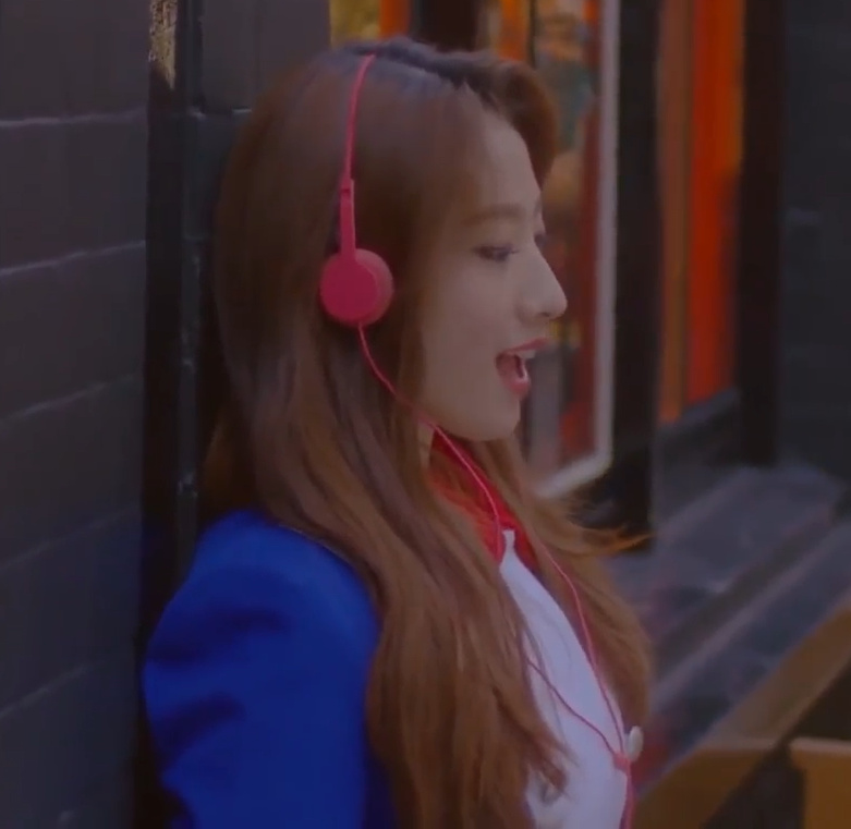 Haseul wearing pink headphones.